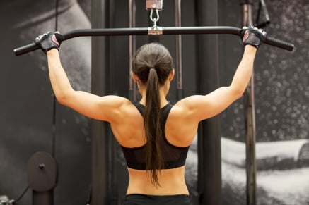 Sportlerin beim Latziehen für ein effektives Rückentraining zuhause