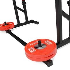 Integrierter Gewichtsscheibenhalter am Squat Rack mit aufgesteckten roten 25-Kilogramm-Hantelscheiben