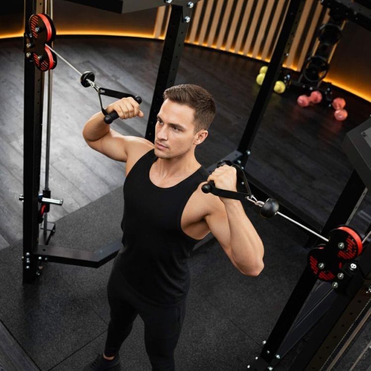 Athlet trainiert Schulter- und Armmuskulatur am Kabelzug eines Power Racks im modernen Fitnessraum