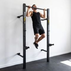 Mann macht Klimmzug an wandmontiertem klappbarem Half Rack