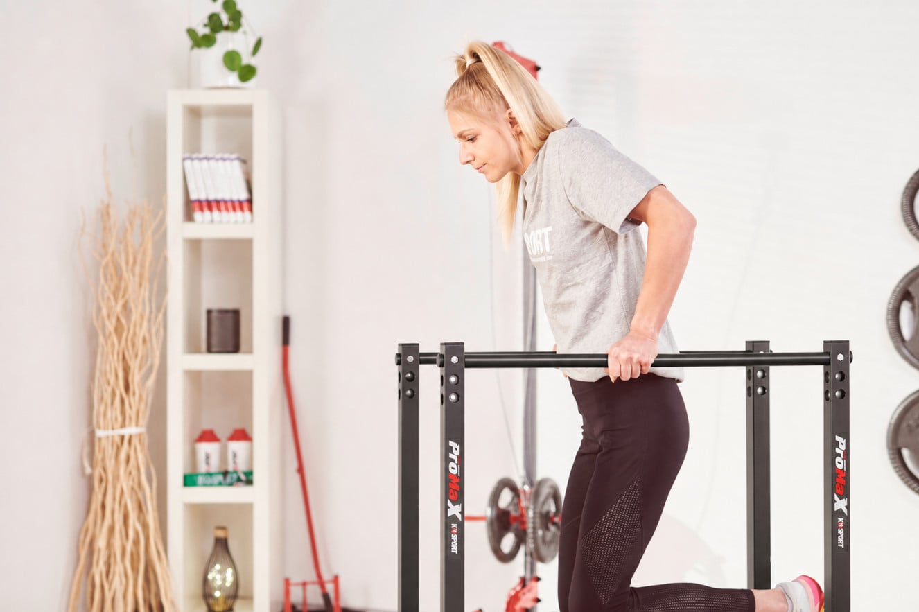 Sportlerin beim Training am schwarzen K-Sport Dip-Barren