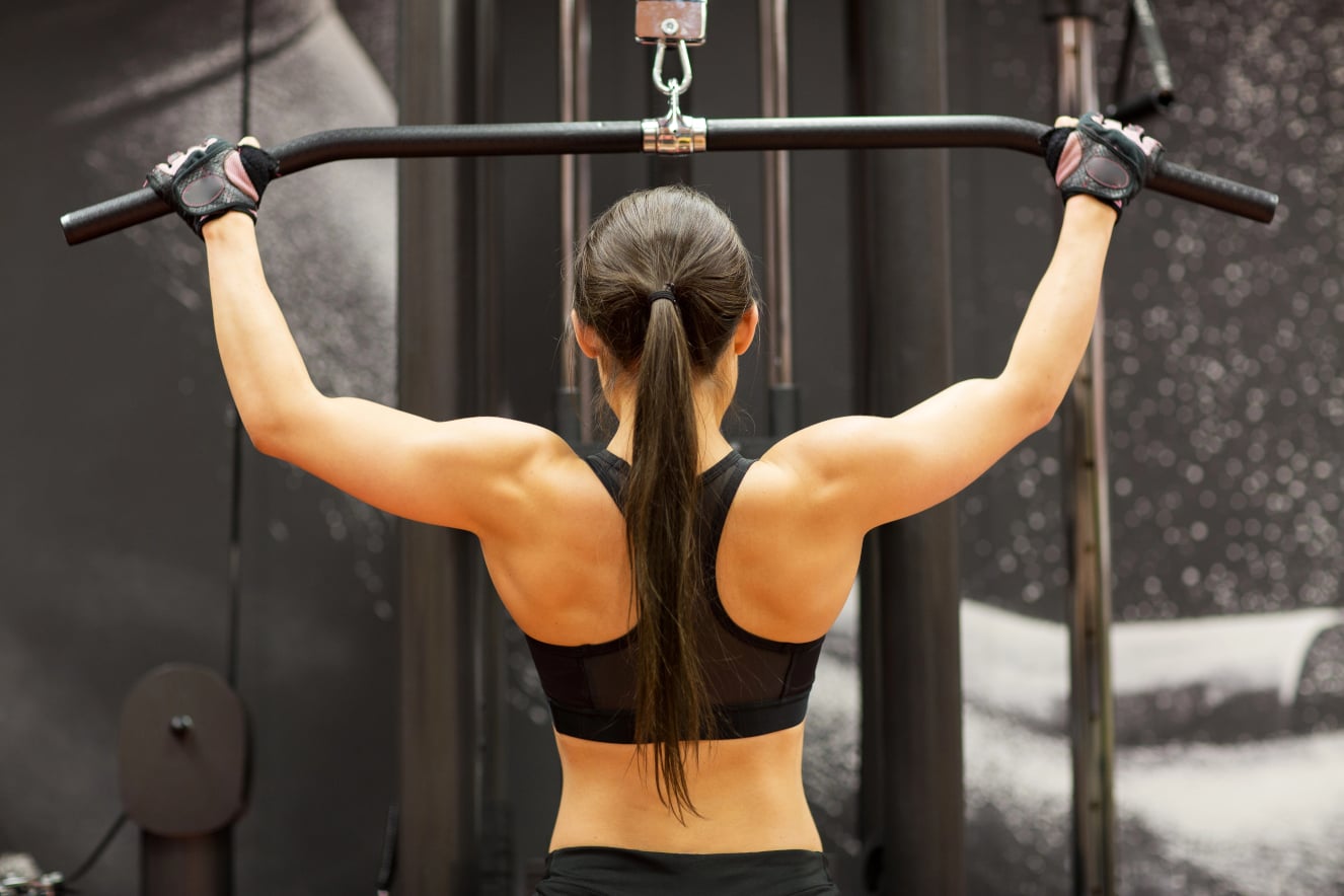 Sportlerin beim Latziehen für ein effektives Rückentraining zuhause