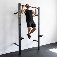 Mann macht Klimmzug an wandmontiertem klappbarem Half Rack