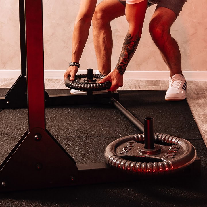 Disques de poids sur la barre T-Bar au Half Rack