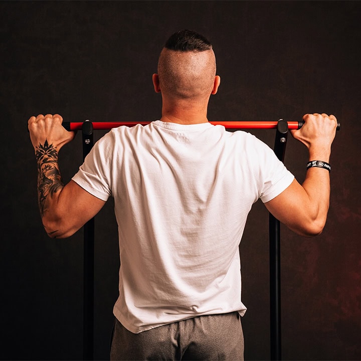 Deportista agarra la barra de dominadas para un entrenamiento