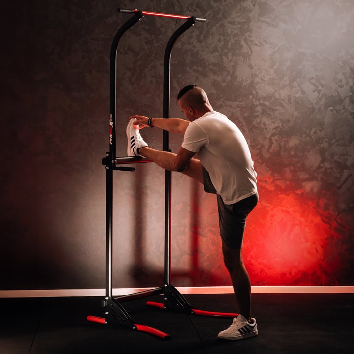 Estiramiento de piernas en la Power Tower para flexibilidad