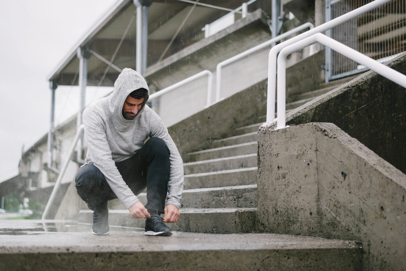 Sporter bereidt zich voor op een buitentraining in regen en koud herfstweer