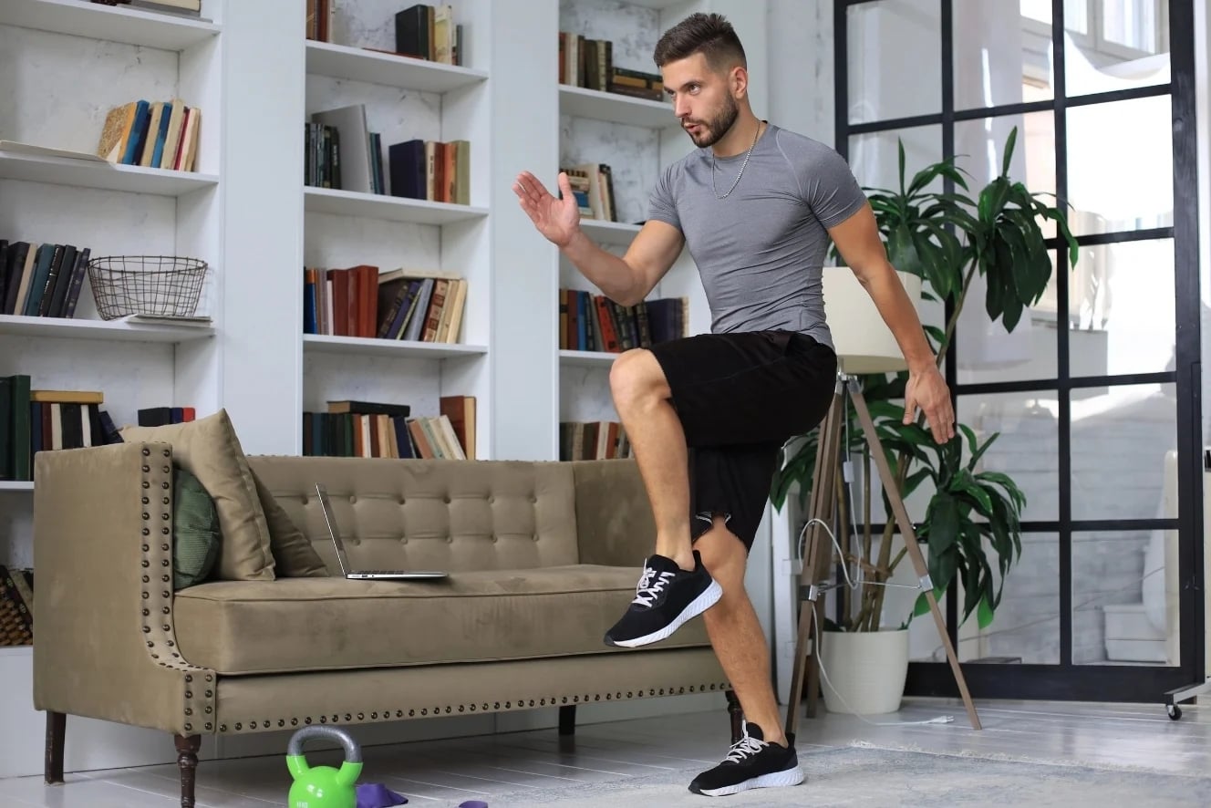 Man doet een intensieve HIIT-training thuis in de woonkamer – korte workout van 20 minuten voor de feestdagen